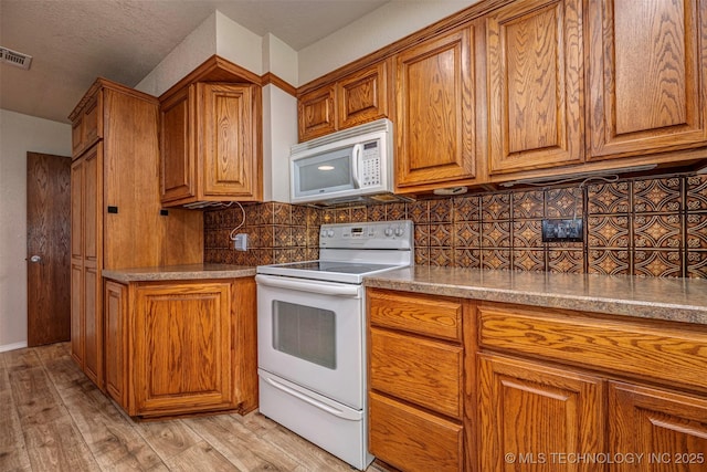 710 N Brethren Rd, Cushing, OK 74023 - kitchen featuring white appliances, brown cabinets, and light wood-type flooring