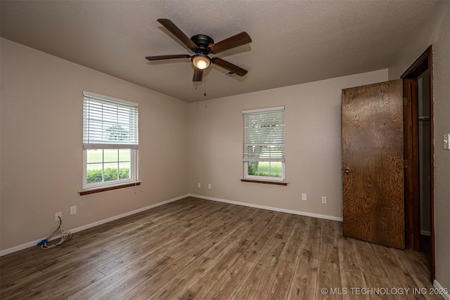 710 N Brethren Rd, Cushing, OK 74023 - spare room with wood finished floors, ceiling fan, and a textured ceiling
