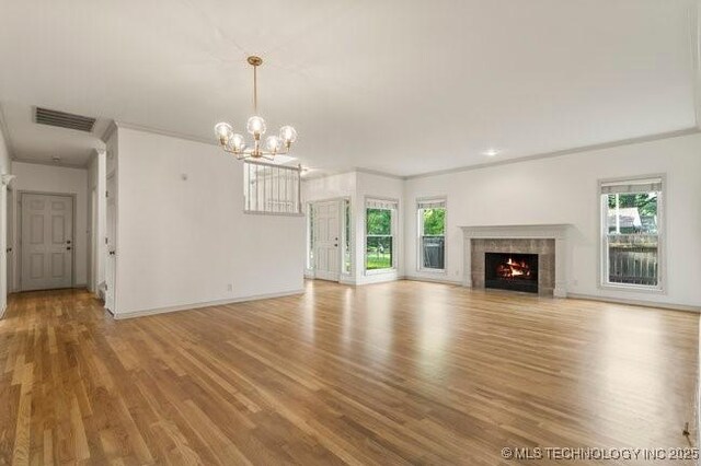 1620 S Florence Pl, Tulsa, OK 74104 - unfurnished living room with light wood-style flooring, a chandelier, a fireplace with flush hearth, and ornamental molding
