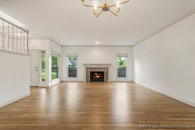 1620 S Florence Pl, Tulsa, OK 74104 - unfurnished living room with a chandelier, wood finished floors, a tiled fireplace, and crown molding