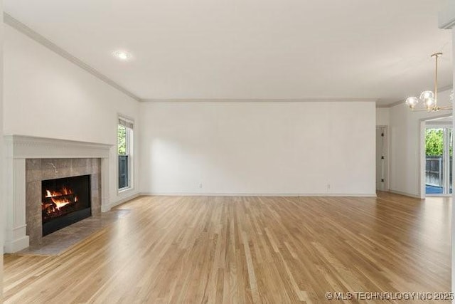 1620 S Florence Pl, Tulsa, OK 74104 - unfurnished living room with ornamental molding, light wood-type flooring, a fireplace, healthy amount of natural light, and a chandelier