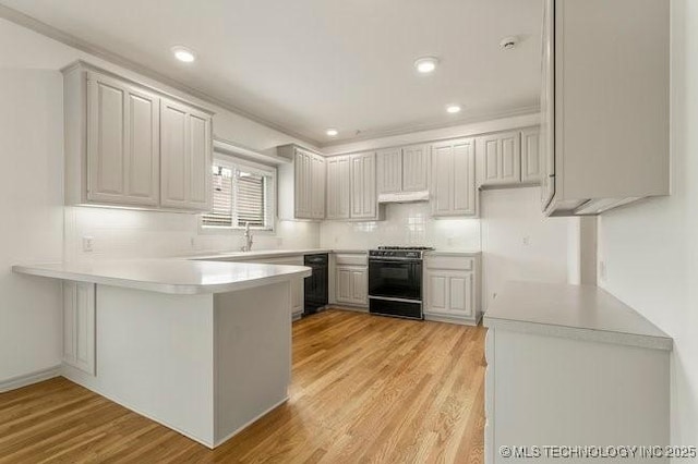1620 S Florence Pl, Tulsa, OK 74104 - kitchen featuring gas range, a peninsula, dishwasher, decorative backsplash, and light wood-style flooring