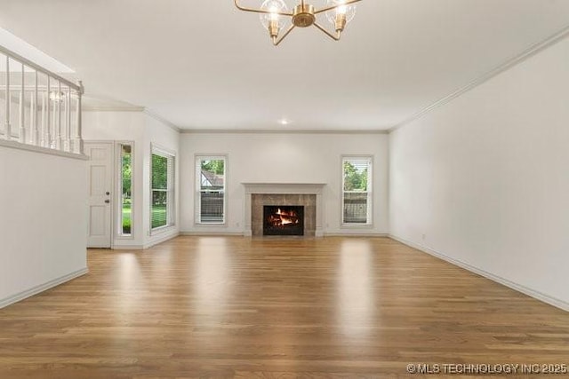 1620 S Florence Pl, Tulsa, OK 74104 - unfurnished living room with plenty of natural light, wood finished floors, a chandelier, and ornamental molding