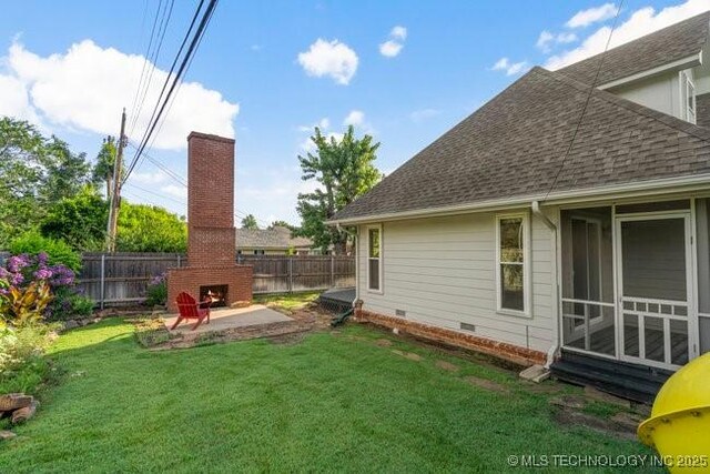 1620 S Florence Pl, Tulsa, OK 74104 - fenced backyard with an outdoor brick fireplace, a patio, and a sunroom