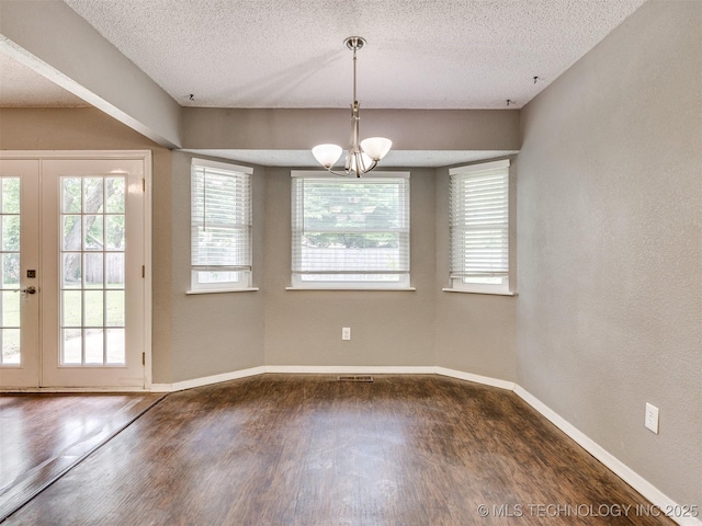 117 W Timberlane St, Broken Arrow, OK 74011 - unfurnished dining area with dark wood-style flooring, a chandelier, a textured ceiling, french doors, and a textured wall