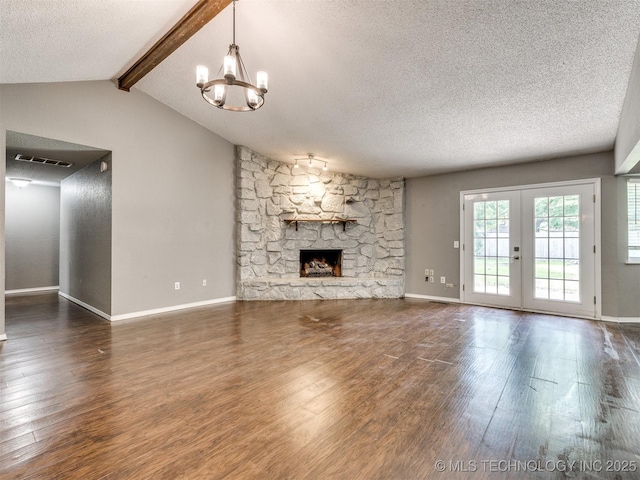 117 W Timberlane St, Broken Arrow, OK 74011 - unfurnished living room featuring a textured ceiling, a chandelier, wood finished floors, a stone fireplace, and french doors