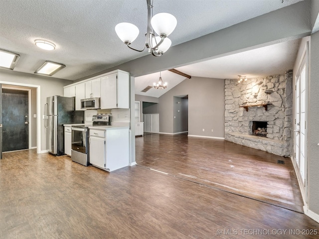 117 W Timberlane St, Broken Arrow, OK 74011 - kitchen with stainless steel appliances, a chandelier, wood finished floors, a fireplace, and white cabinets