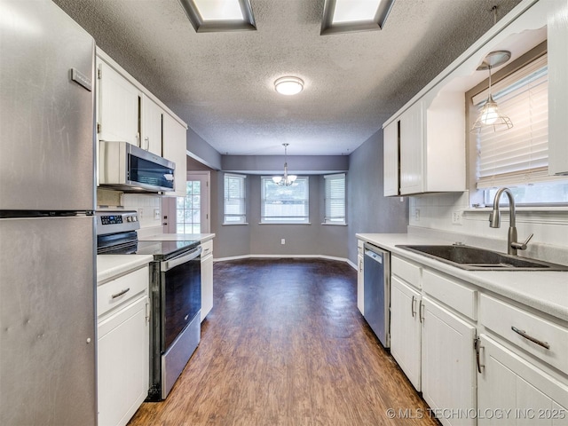 117 W Timberlane St, Broken Arrow, OK 74011 - kitchen featuring stainless steel appliances, dark wood-style flooring, a chandelier, a textured ceiling, and white cabinetry