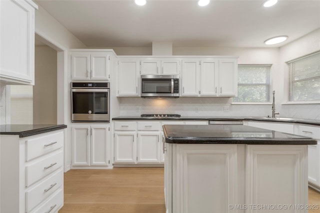 6905 S Redbud Ave, Broken Arrow, OK 74011 - kitchen with appliances with stainless steel finishes, dark countertops, white cabinets, light wood-style flooring, and recessed lighting