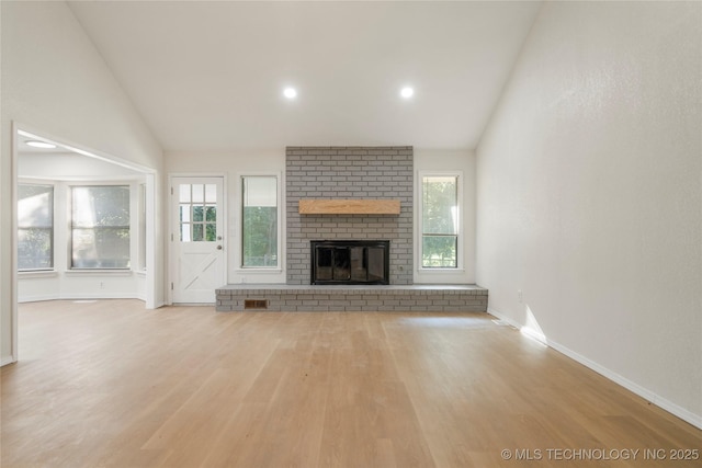 6905 S Redbud Ave, Broken Arrow, OK 74011 - unfurnished living room featuring vaulted ceiling, wood finished floors, healthy amount of natural light, a brick fireplace, and recessed lighting