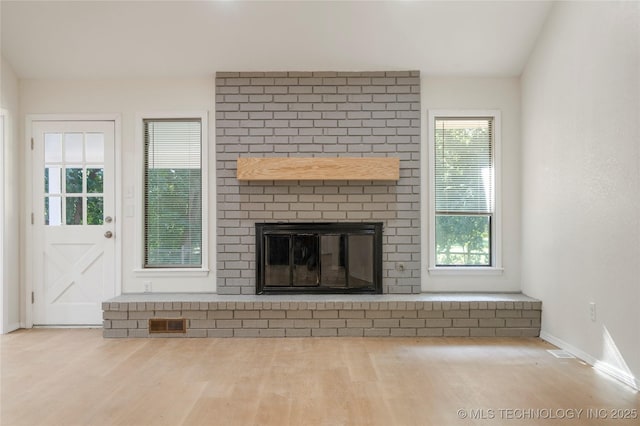6905 S Redbud Ave, Broken Arrow, OK 74011 - unfurnished living room with wood finished floors and a brick fireplace
