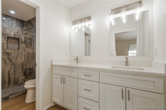 6905 S Redbud Ave, Broken Arrow, OK 74011 - bathroom featuring double vanity, a tile shower, and wood finished floors