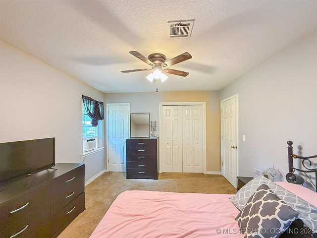 14174 County Road 3501, Ada, OK 74820 - bedroom with light carpet, a textured ceiling, a ceiling fan, cooling unit, and two closets