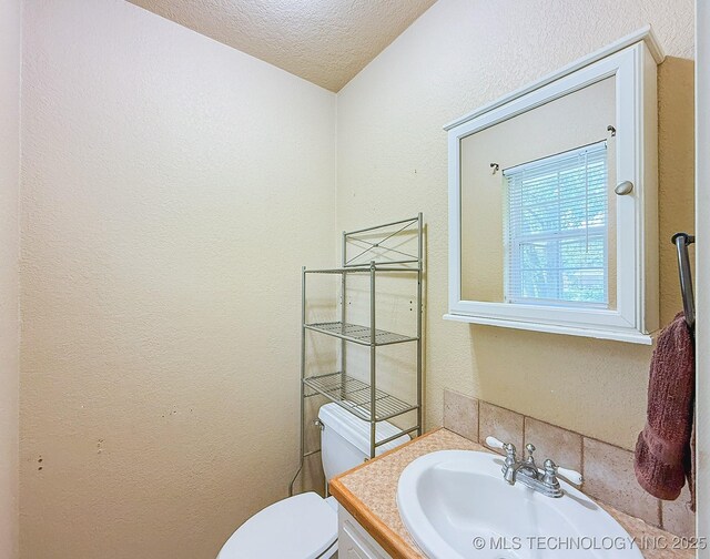 14174 County Road 3501, Ada, OK 74820 - half bathroom with a textured ceiling, vanity, and a textured wall