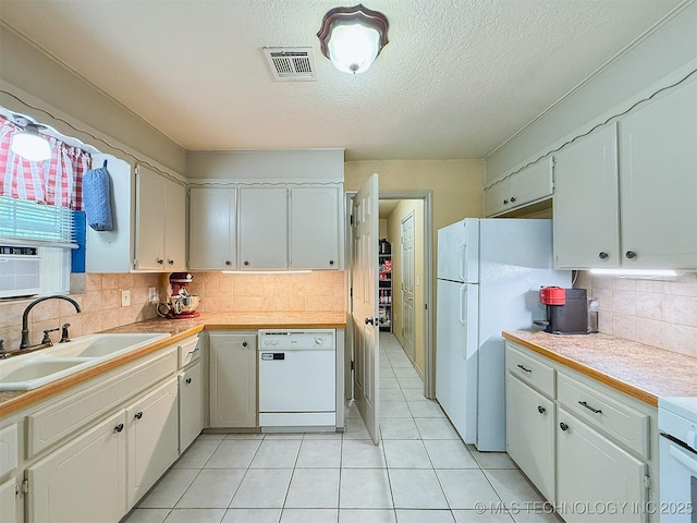 14174 County Road 3501, Ada, OK 74820 - kitchen featuring white appliances, light tile patterned floors, backsplash, white cabinets, and a textured ceiling