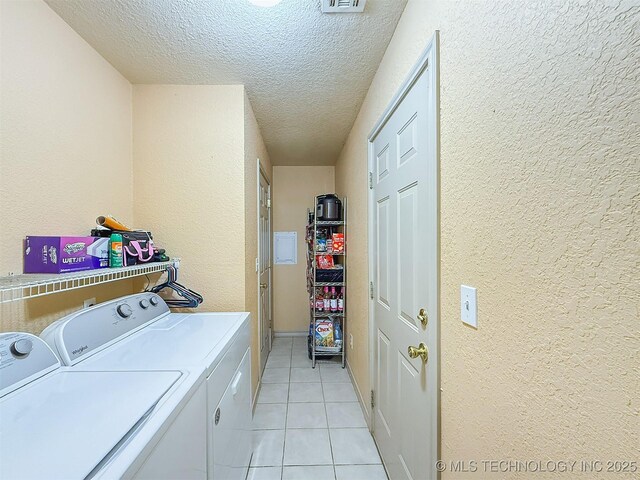 14174 County Road 3501, Ada, OK 74820 - laundry room featuring a textured wall, separate washer and dryer, a textured ceiling, and light tile patterned flooring