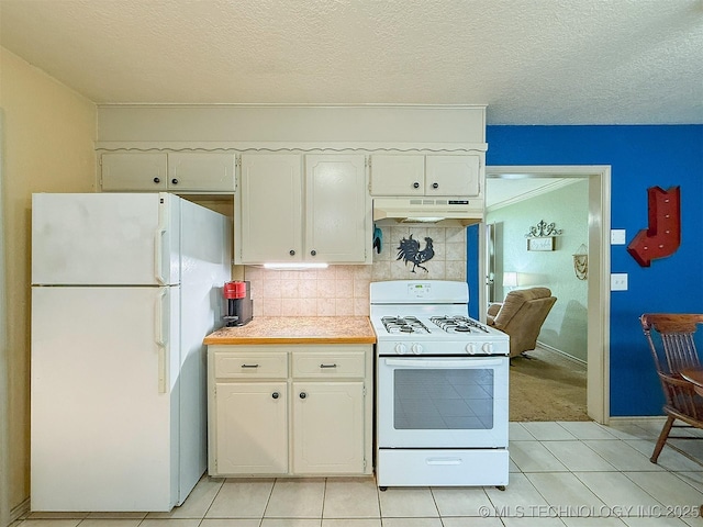 14174 County Road 3501, Ada, OK 74820 - kitchen with white appliances, under cabinet range hood, light countertops, white cabinetry, and light tile patterned floors