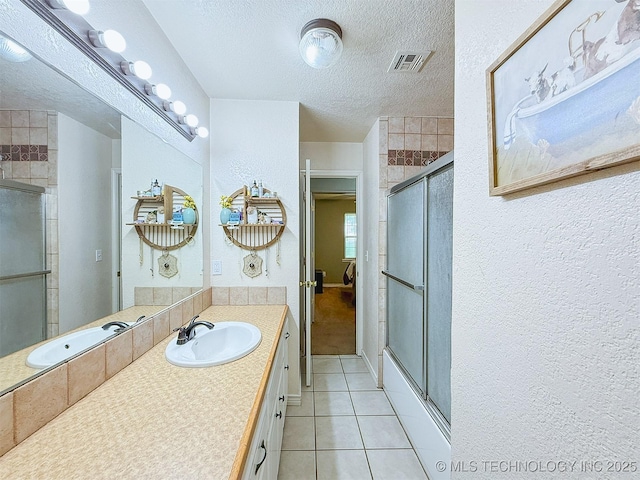 14174 County Road 3501, Ada, OK 74820 - full bathroom featuring tile patterned floors, a textured ceiling, a shower stall, vanity, and a textured wall