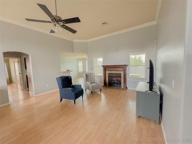 13155 E 132nd St N, Collinsville, OK 74021 - sitting room featuring a tiled fireplace, ceiling fan, crown molding, light wood-style floors, and a towering ceiling