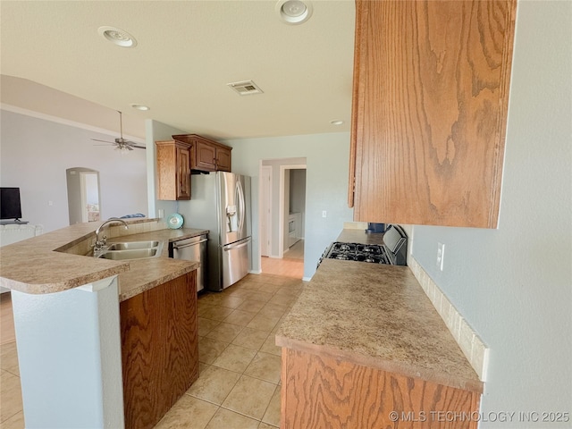 13155 E 132nd St N, Collinsville, OK 74021 - kitchen with appliances with stainless steel finishes, a peninsula, light countertops, ceiling fan, and light tile patterned floors