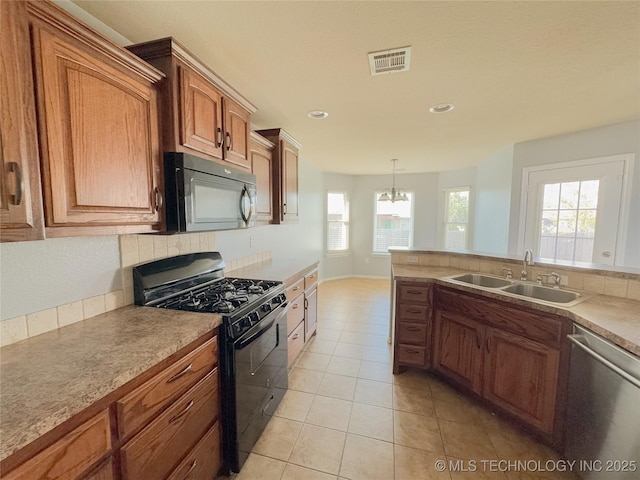 13155 E 132nd St N, Collinsville, OK 74021 - kitchen with black appliances, a chandelier, brown cabinetry, decorative backsplash, and recessed lighting