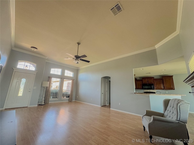 13155 E 132nd St N, Collinsville, OK 74021 - living room with ceiling fan, ornamental molding, a towering ceiling, arched walkways, and light wood-style flooring