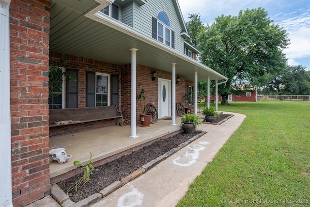 105074 N 3770, Okemah, OK 74859 - doorway to property with a porch, a lawn, and brick siding