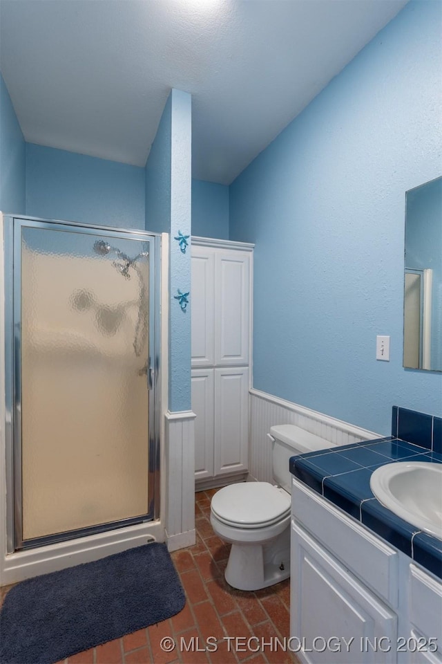 105074 N 3770, Okemah, OK 74859 - bathroom with a stall shower, vanity, a wainscoted wall, and brick patterned flooring