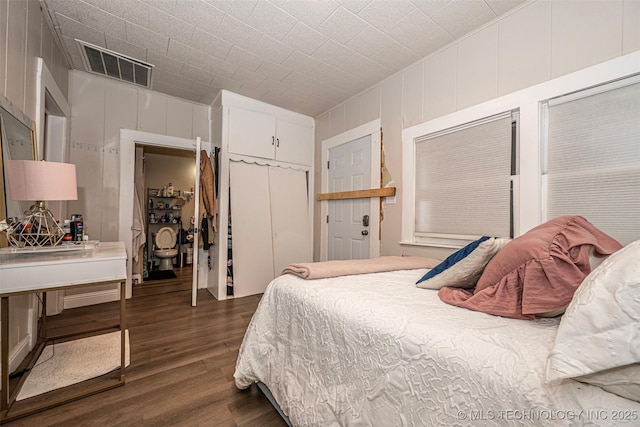 1208 NW 1st Ave, Ardmore, OK 73401 - bedroom featuring dark wood finished floors, a closet, and a decorative wall