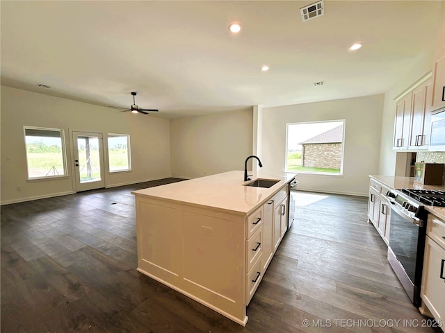 10416 E 132nd St S, Bixby, OK 74008 - kitchen with stainless steel gas range, a ceiling fan, dark wood-style floors, a kitchen island with sink, and recessed lighting
