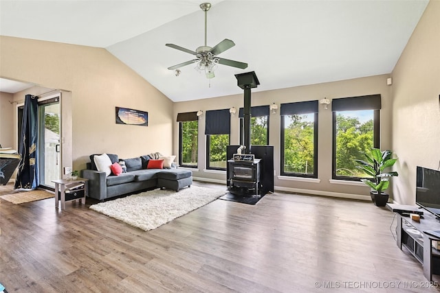 3104 Howard St, Sand Springs, OK 74063 - living area featuring a wood stove, a ceiling fan, vaulted ceiling, and wood finished floors
