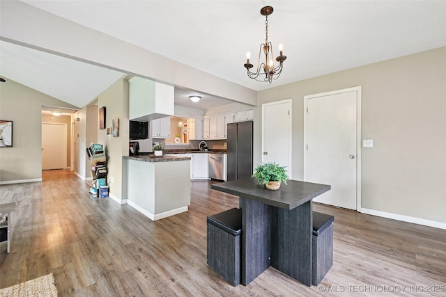 3104 Howard St, Sand Springs, OK 74063 - kitchen with dark countertops, appliances with stainless steel finishes, a chandelier, wood finished floors, and vaulted ceiling
