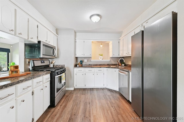 3104 Howard St, Sand Springs, OK 74063 - kitchen featuring appliances with stainless steel finishes, dark countertops, light wood-style floors, and white cabinetry