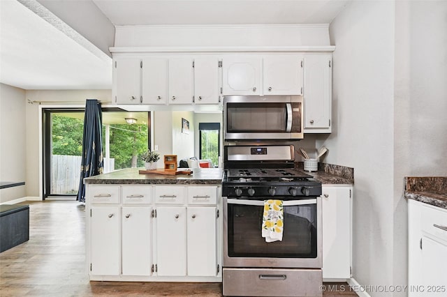 3104 Howard St, Sand Springs, OK 74063 - kitchen with stainless steel appliances, dark countertops, white cabinets, and wood finished floors