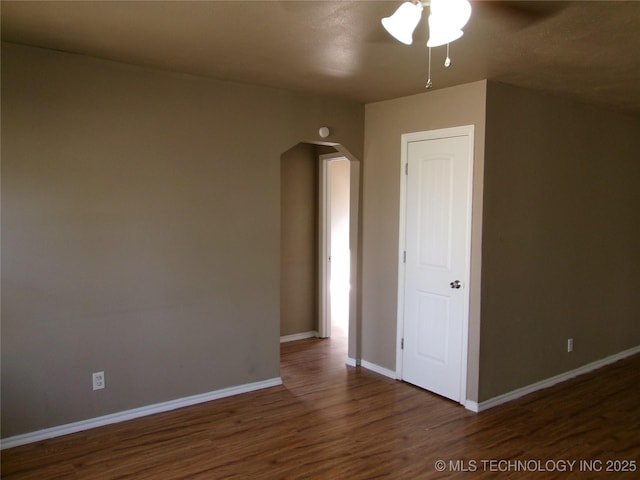 2131 Topeka St, Muskogee, OK 74403 - empty room featuring arched walkways, a ceiling fan, and wood finished floors