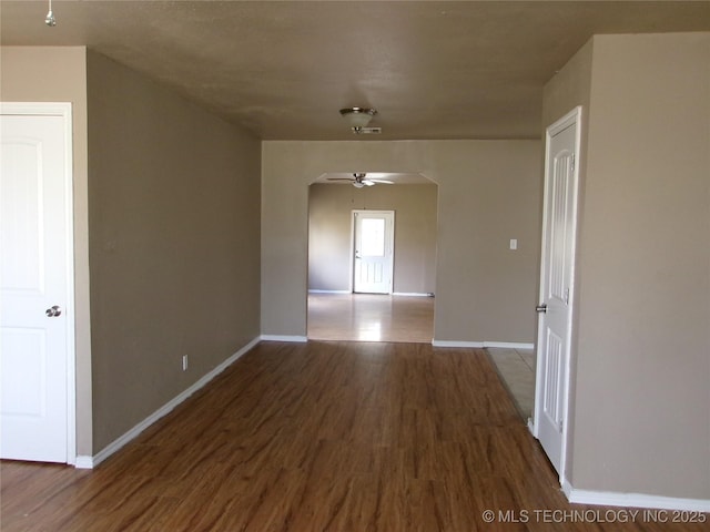 2131 Topeka St, Muskogee, OK 74403 - empty room featuring arched walkways, wood finished floors, and a ceiling fan
