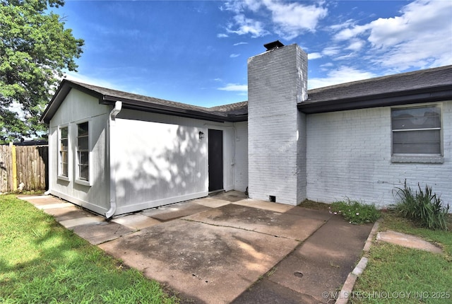 10046 E 29th St, Tulsa, OK 74129 - back of house featuring a chimney, a patio, and brick siding