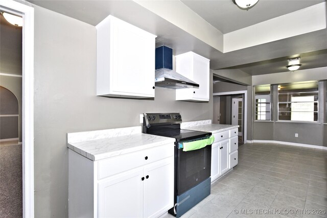 10046 E 29th St, Tulsa, OK 74129 - kitchen featuring black / electric stove, wall chimney range hood, white cabinets, and light tile patterned floors