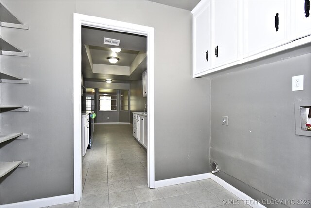 10046 E 29th St, Tulsa, OK 74129 - washroom with cabinet space, electric dryer hookup, light tile patterned floors, and washer hookup