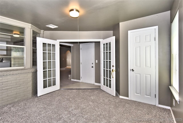 10046 E 29th St, Tulsa, OK 74129 - spare room featuring french doors, carpet flooring, and arched walkways