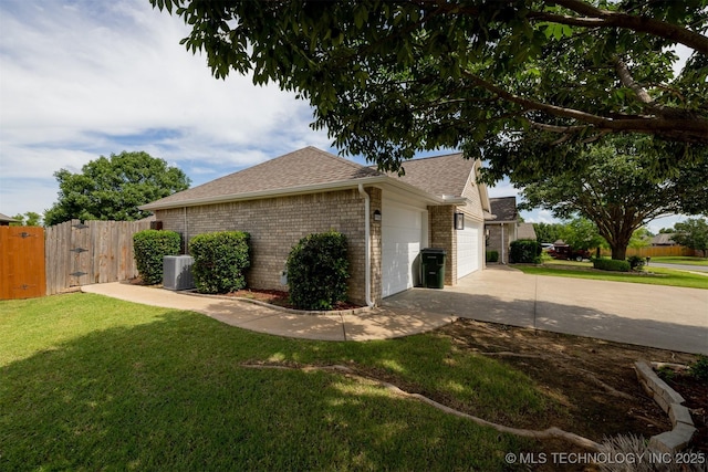 9904 N 102nd E Ave, Owasso, OK 74055 - view of home's exterior with a gate, an attached garage, concrete driveway, a shingled roof, and brick siding