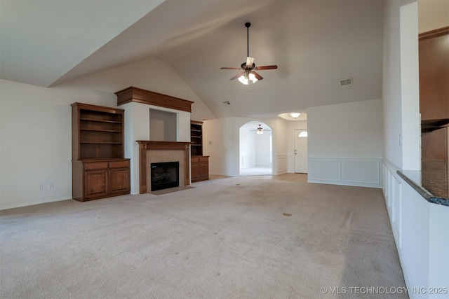 9904 N 102nd E Ave, Owasso, OK 74055 - unfurnished living room with ceiling fan, a decorative wall, a fireplace with flush hearth, light carpet, and wainscoting