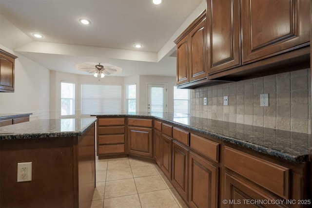 9904 N 102nd E Ave, Owasso, OK 74055 - kitchen featuring ceiling fan, recessed lighting, light tile patterned floors, tasteful backsplash, and dark stone counters