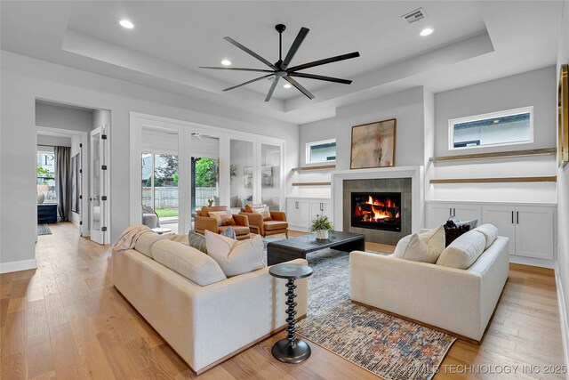 9613 E 119th Ct S, Bixby, OK 74008 - living area featuring a tray ceiling, recessed lighting, a tile fireplace, and light wood-type flooring