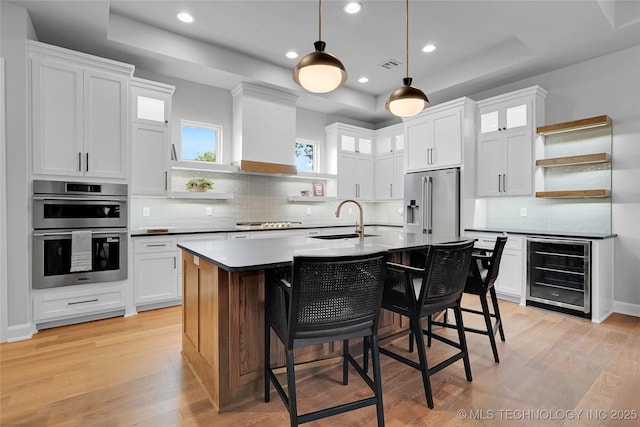 9613 E 119th Ct S, Bixby, OK 74008 - kitchen with beverage cooler, open shelves, appliances with stainless steel finishes, a kitchen breakfast bar, and light wood-style floors