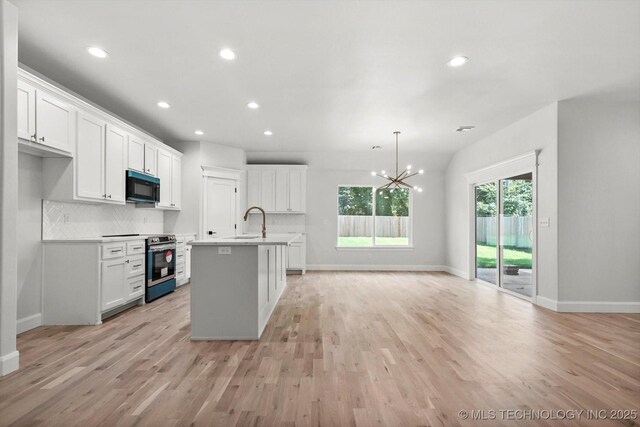 13236 E 4th Pl, Tulsa, OK 74108 - kitchen featuring black microwave, stainless steel electric stove, a chandelier, white cabinets, and light countertops