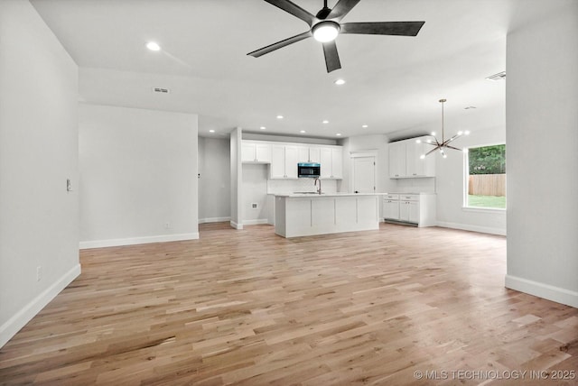 13236 E 4th Pl, Tulsa, OK 74108 - unfurnished living room featuring a chandelier, light wood-type flooring, a ceiling fan, and recessed lighting