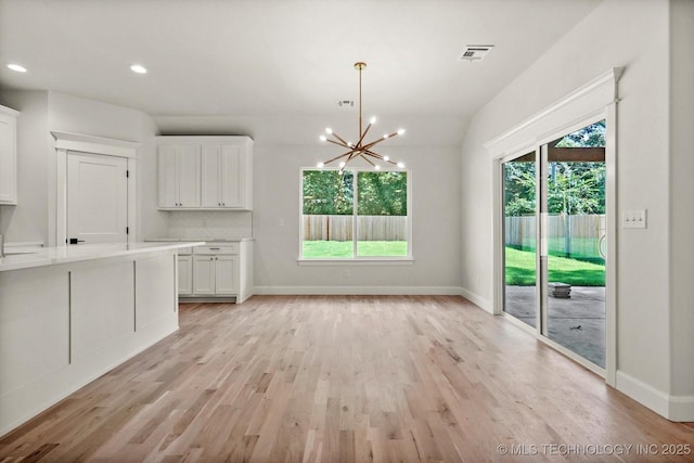 13236 E 4th Pl, Tulsa, OK 74108 - unfurnished dining area with healthy amount of natural light, a chandelier, light wood finished floors, and recessed lighting