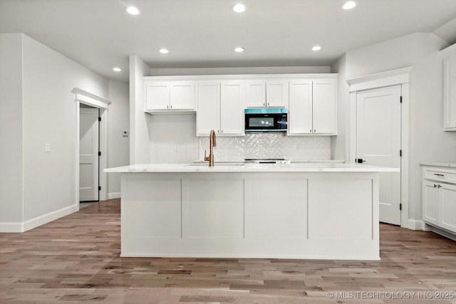 13236 E 4th Pl, Tulsa, OK 74108 - kitchen with black microwave, white cabinetry, light wood finished floors, backsplash, and recessed lighting