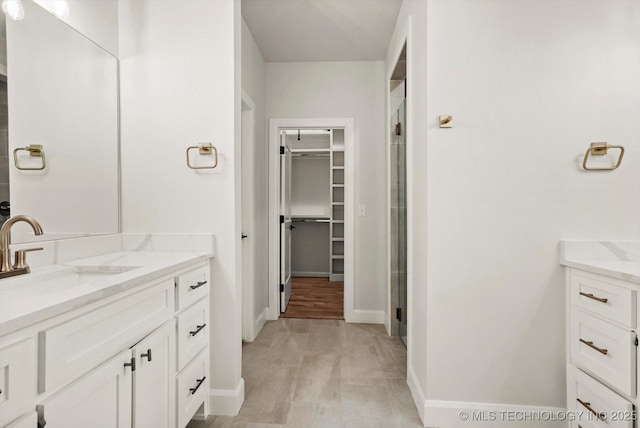 13236 E 4th Pl, Tulsa, OK 74108 - bathroom featuring vanity, a spacious closet, and a stall shower
